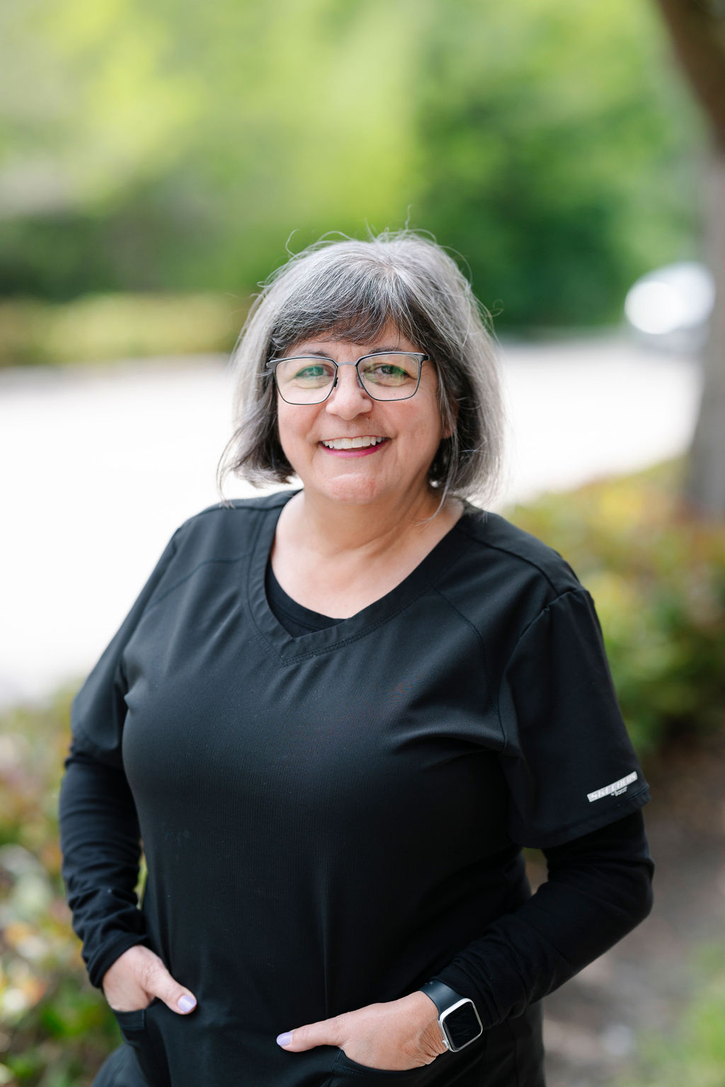 Pam – Experienced Dental Hygienist at Suncoast Dental Center - suncoast dental center reviews Pam, an experienced dental hygienist, smiles warmly while standing outdoors in her professional uniform, representing compassionate dental care at Suncoast Dental Center. - suncoast dental center reviews